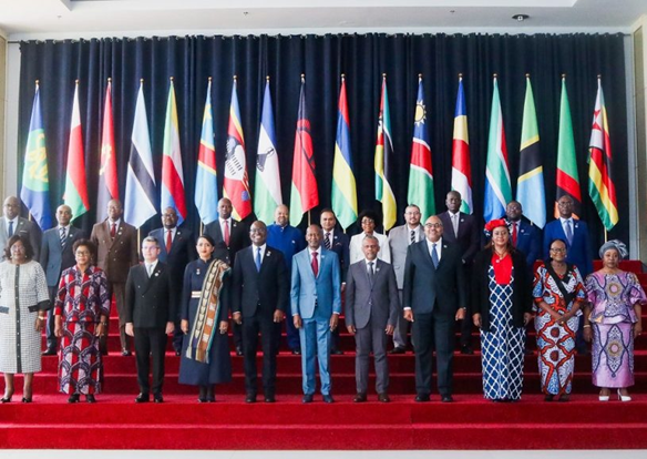 SADC delegates and dignitaries standing before national flags at the summit