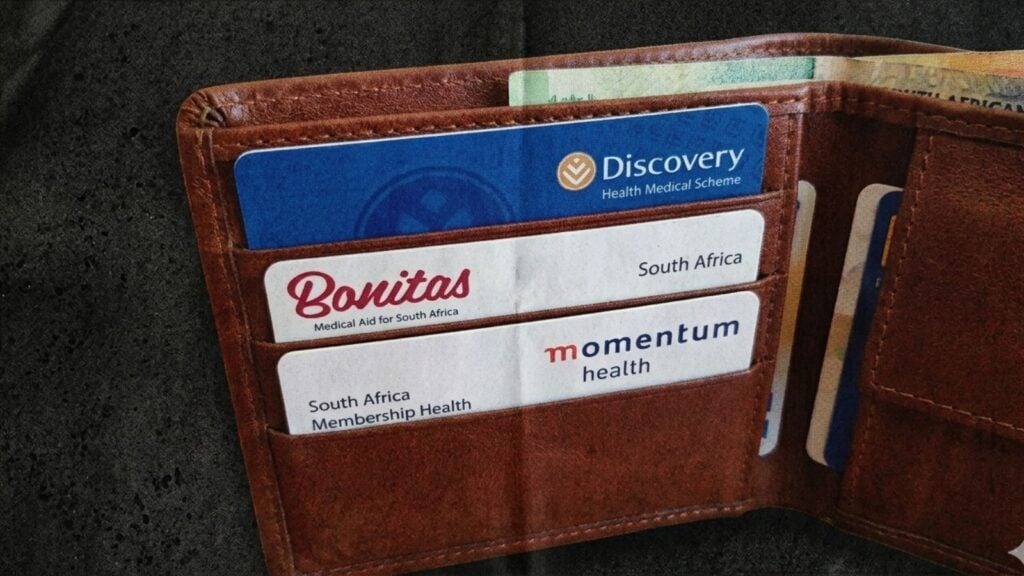 Wallet containing multiple South African medical aid cards including Discovery, Bonitas, Momentum, and others